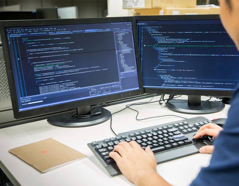 Person working with code on desktop computers