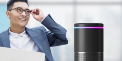 Man standing behing a smart speaker