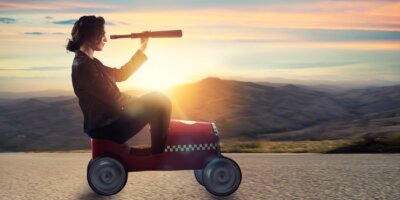 businesswoman with telescope on a car looks for new business