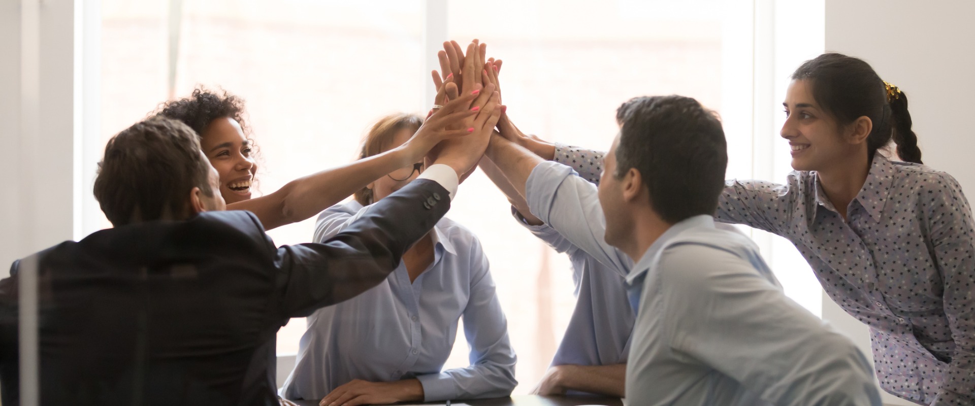 excited multi racial businesspeople celebrating corporate success