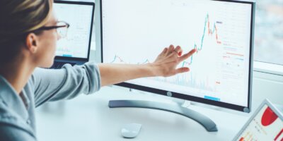 Business woman studying financial market on computer screen