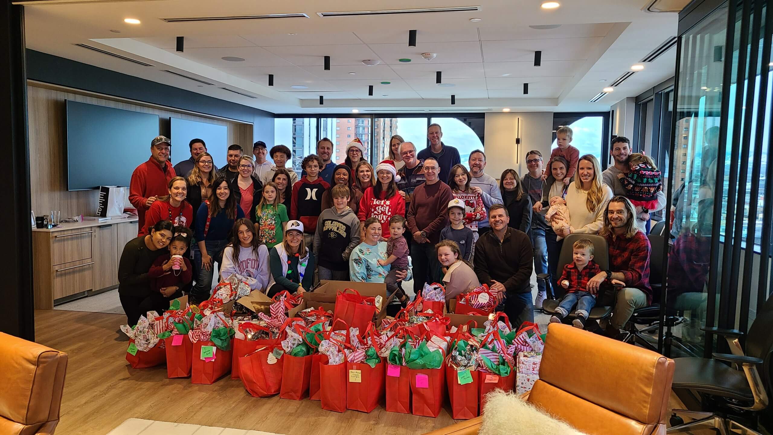 RevGen volunteers pose after wrapping donated holiday gifts for 59 children from Valverde Elementary