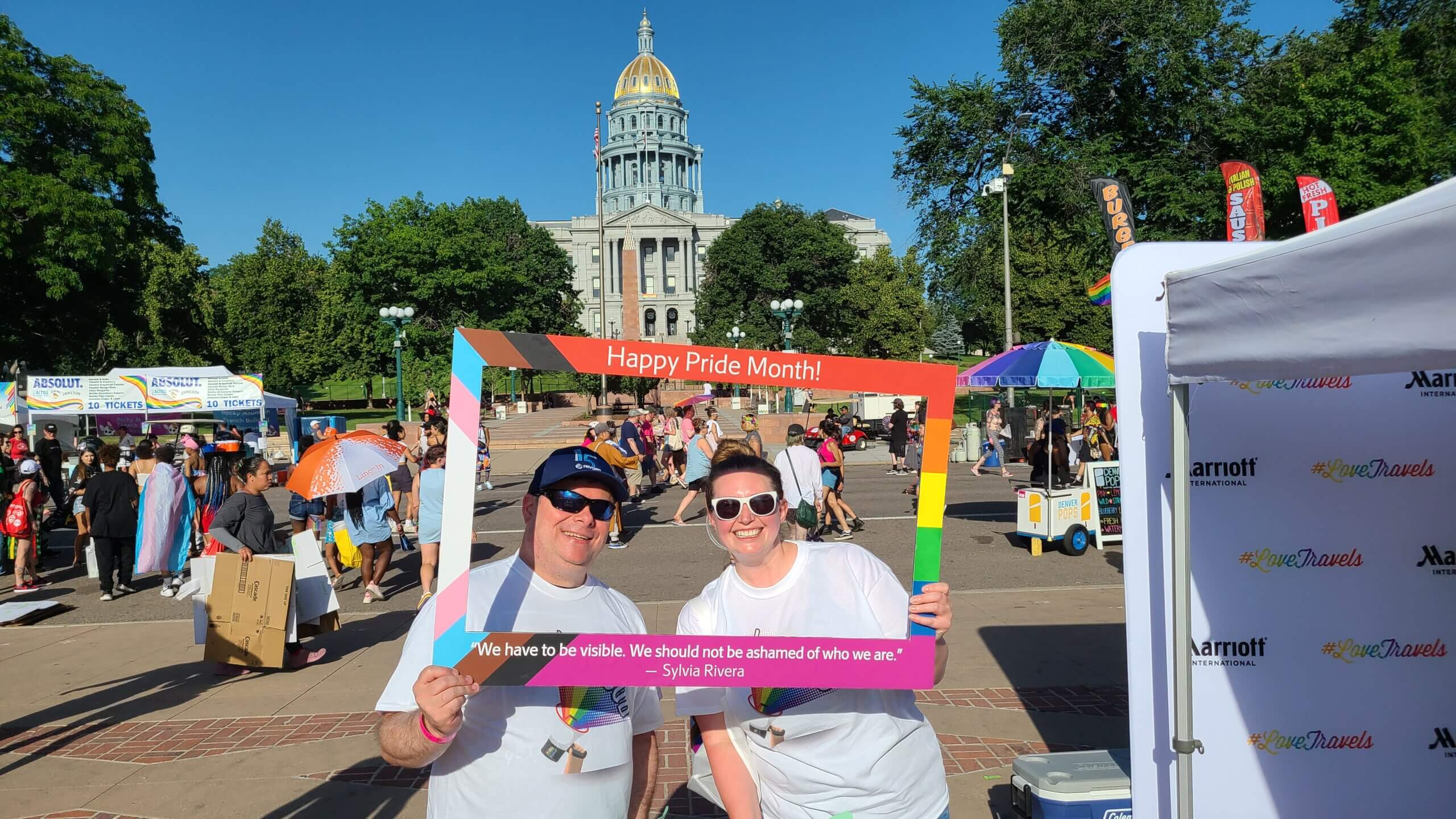 Two RevGen Volunteers pose in front of the Colorado State Capital as they volunteer at the Denver Pride Festival