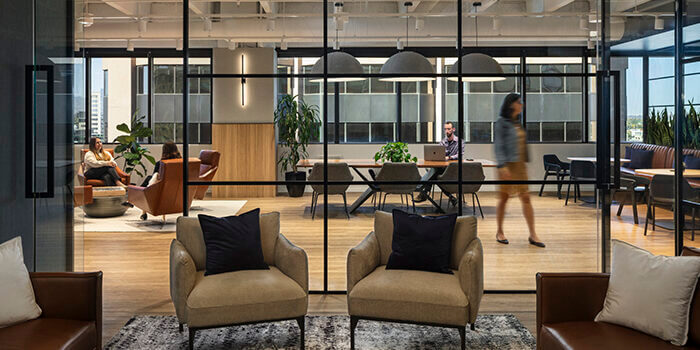 A view from the RevGen lounge into the lobby, where several coworkers chat.