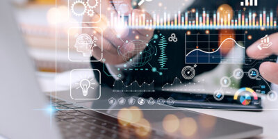 A hologram of a data visualization with multiple charts on a single dashboard floats over a laptop